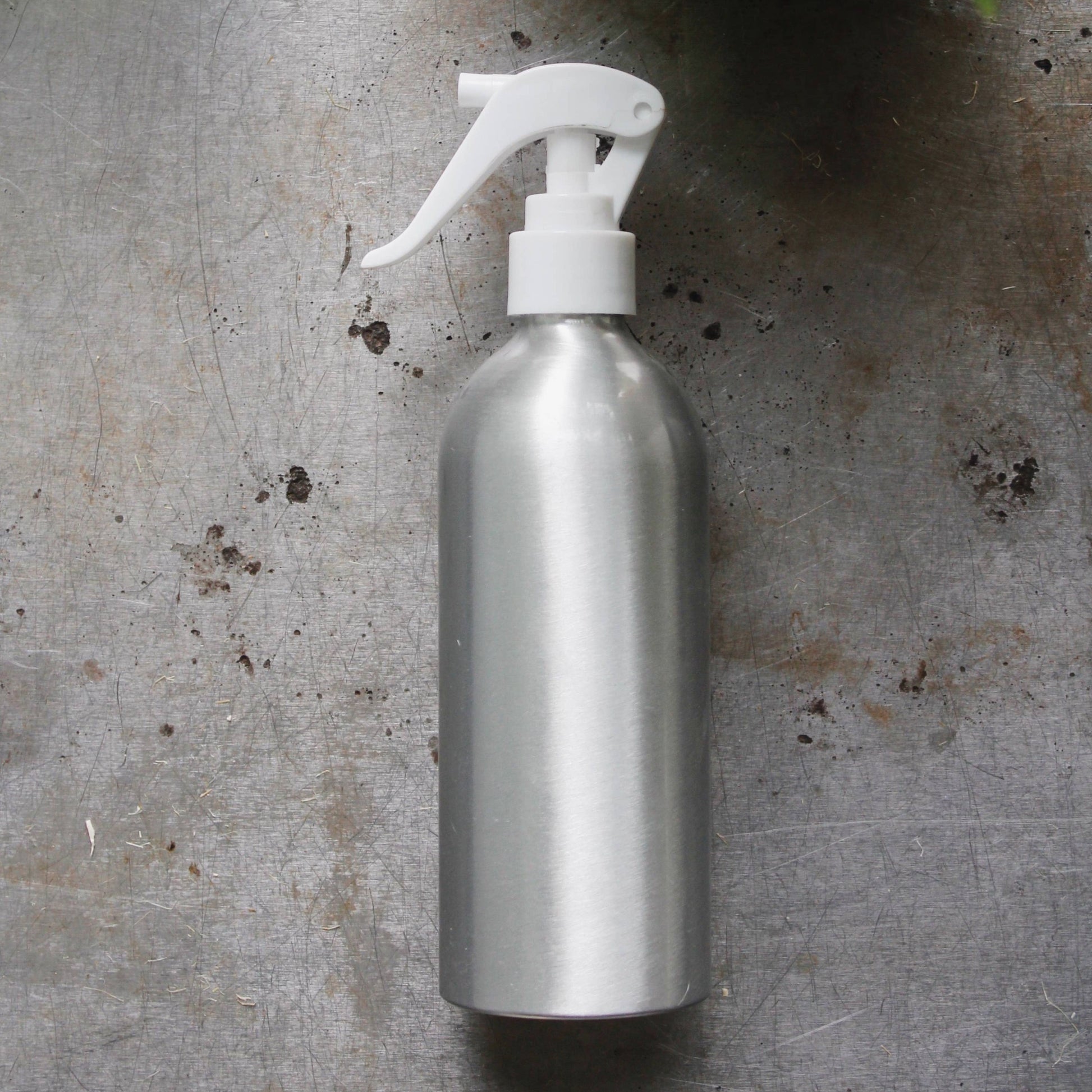Aluminum spray bottle with white spraying top for gardening, house plants, or cleaning needs.