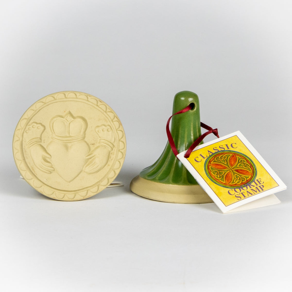 Stoneware ceramic cookie stamp by Emerson Creek. Claddagh design. Comes with small booklet with cookie recipes attached. Green handle.