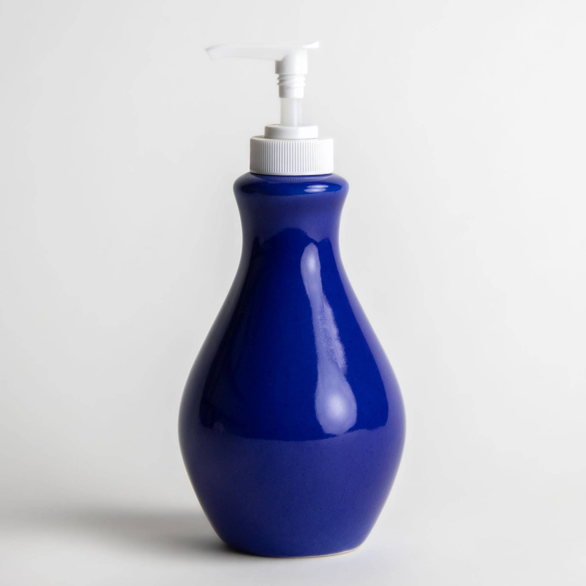 Stoneware refillable soap or lotion bottle with a white pump top. Vibrant blue color. Zero waste home. 