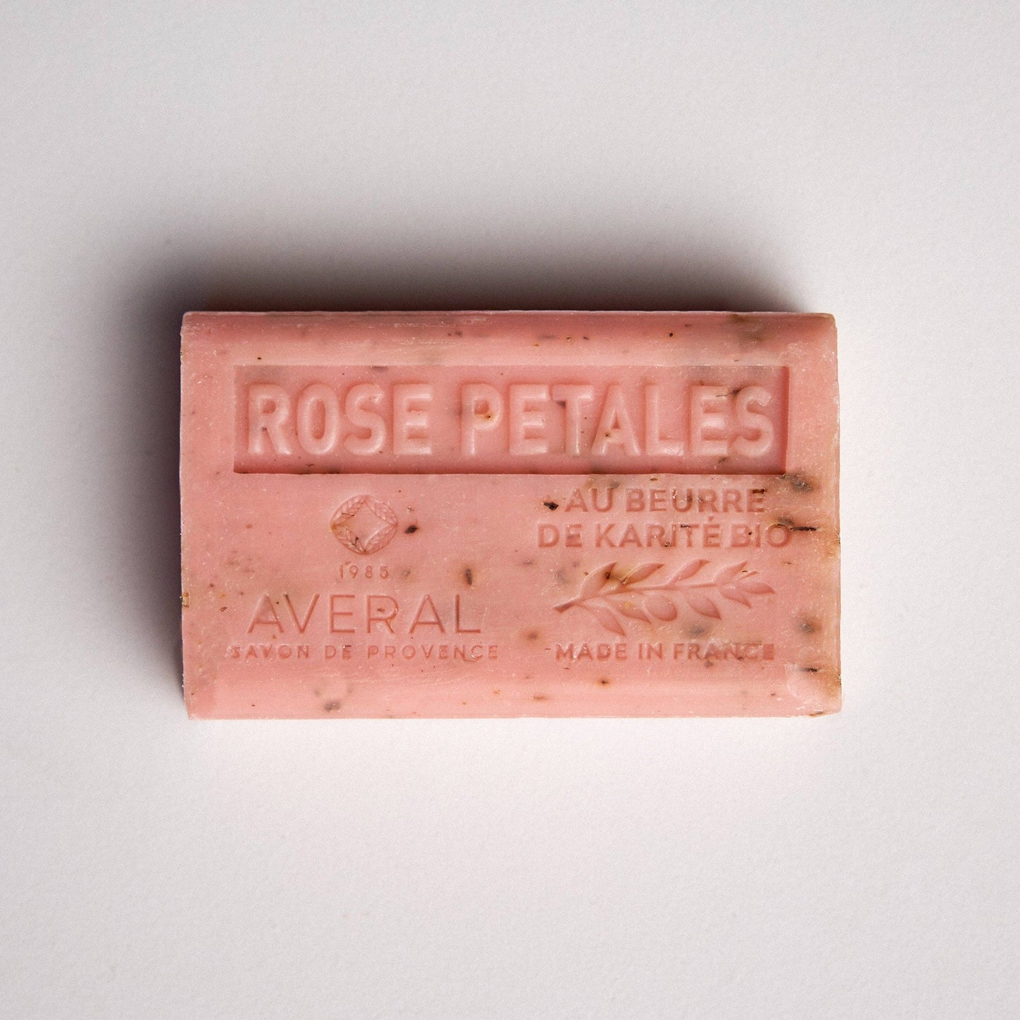 Pink bar of soap with exfoliating texture. Stamped with Rose Petales , au beurre de karite bio, made in france, averal savon de provence on the front. Gentle rose french bar of soap.