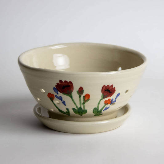 Cream colored ceramic berry colander with  poppies and other flowers hand painted on the side. Handmade in USA. Stoneware. 