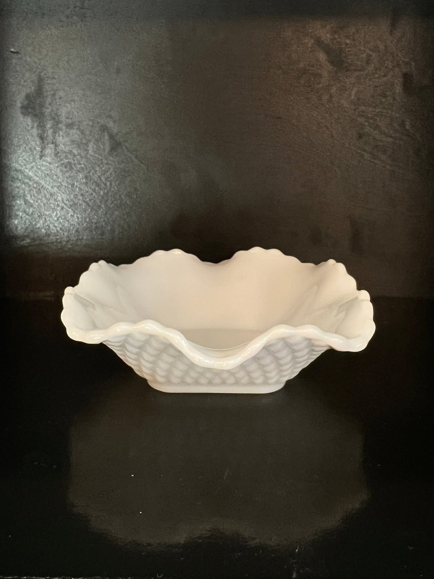 White ceramic foot sculpture on a dark textured surface