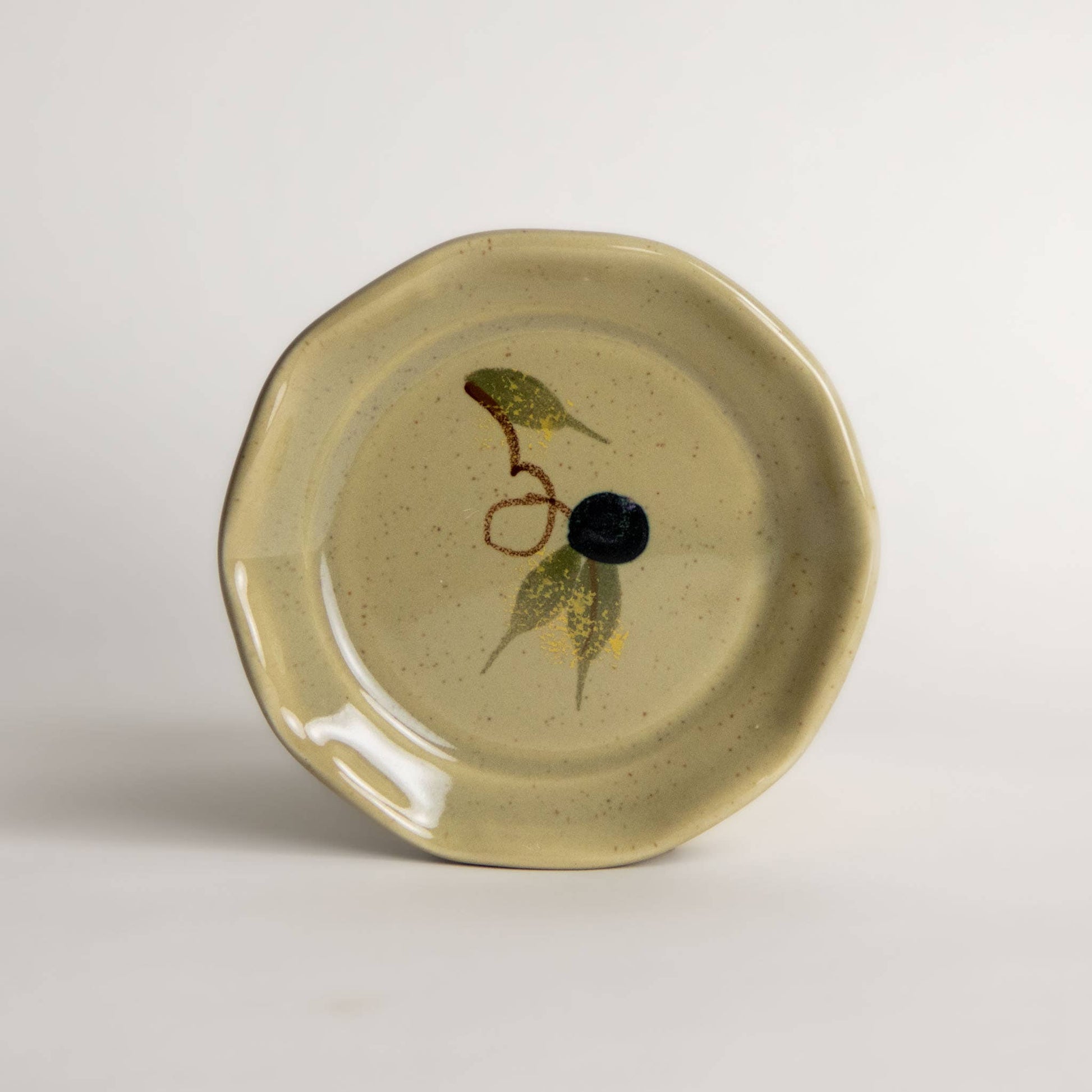 Round beige speckled stoneware small dish with an olive and leaves hand painted design. 