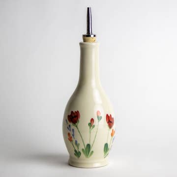 Creamy white with hand painted poppy and other wildflowers stoneware olive oil or vinegar drizzle bottle with a cork and metal drizzle top.