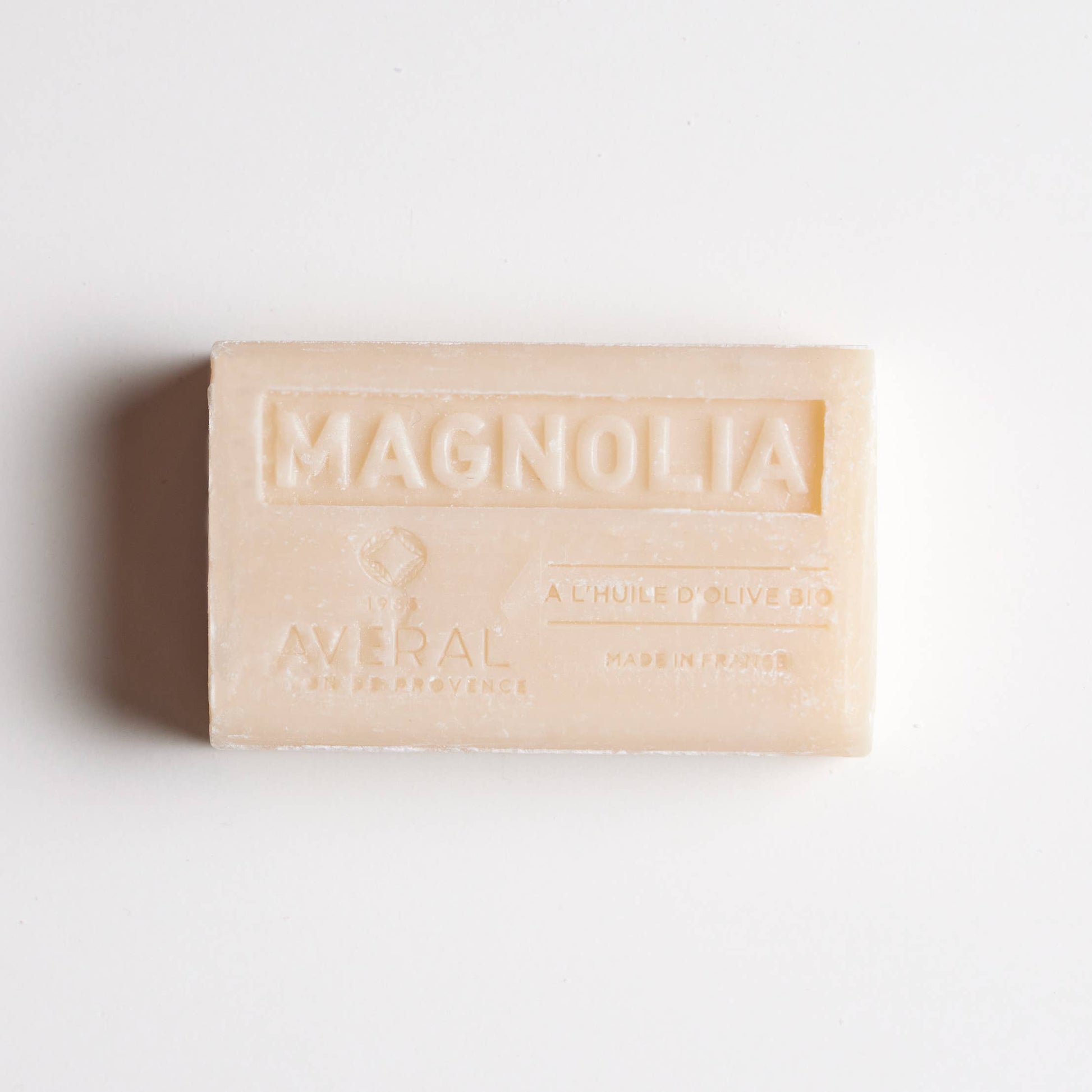 Creamy white color bar of soap. Stamped with Magnolia , a l'huile d'olive bio, made in france, averal savon de provence on the front. Gentle magnolia french bar of soap.