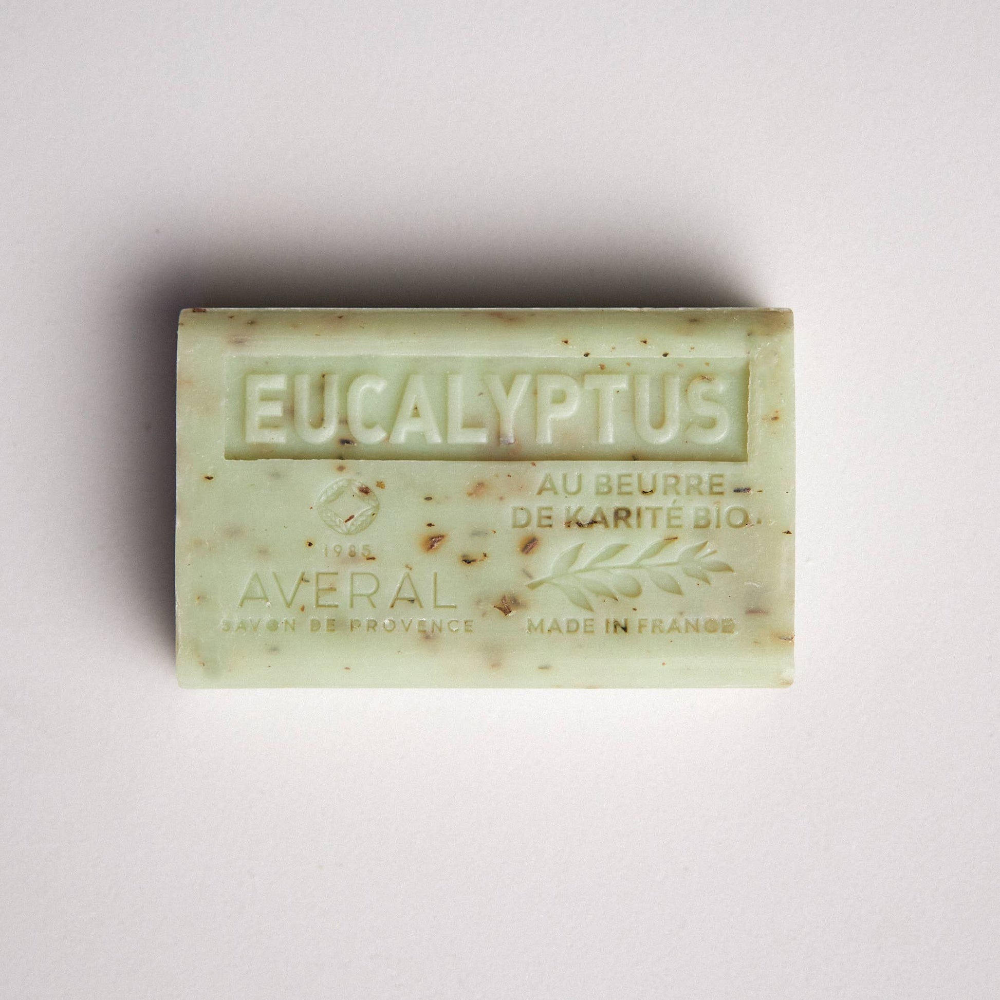 Light green bar of soap with exfoliating texture. Stamped with Eucalyptus, au beurre de karite bio, made in france, averal savon de provence on the front. Eucalyptus honey french bar of soap. 