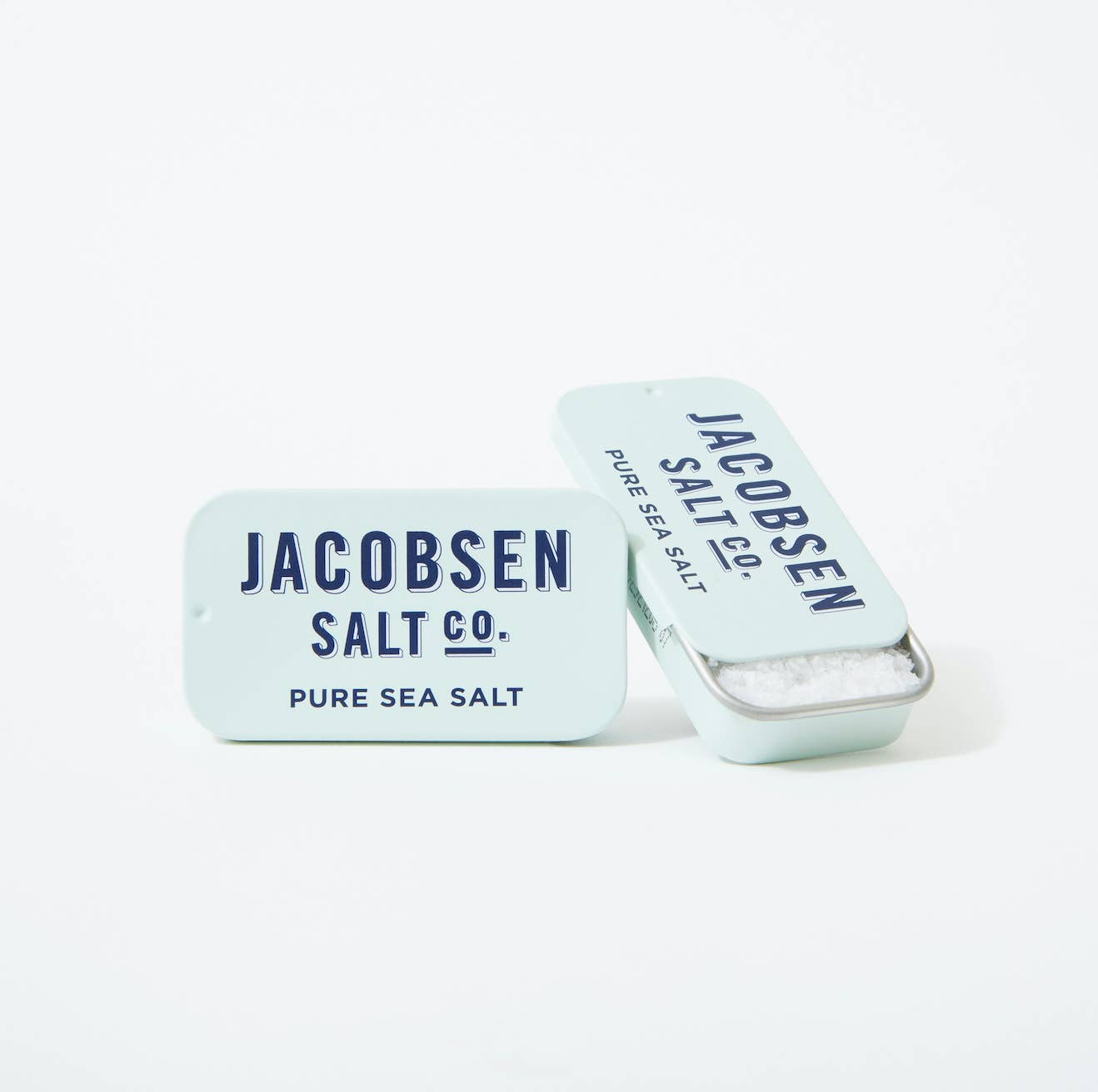 Small metal slide tin with blue Jacobsen Salt Co branding. Pure sea salt in a small tin container. 